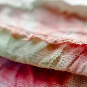 Detailed close-up of vibrant tie-dye cotton textiles with soft focus showcasing fabric texture.