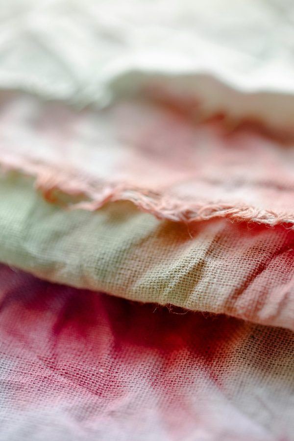 Detailed close-up of vibrant tie-dye cotton textiles with soft focus showcasing fabric texture.